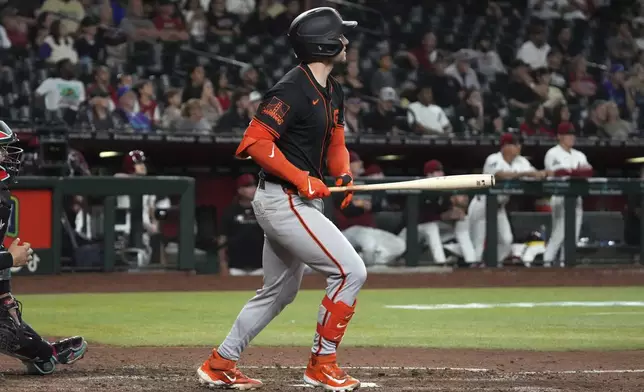 San Francisco Giants' Patrick Bailey hits a sacrifice RBI fly out against the Arizona Diamondbacks in the tenth inning during a baseball game, Wednesday, July 2, 2025, in Phoenix. (AP Photo/Rick Scuteri)