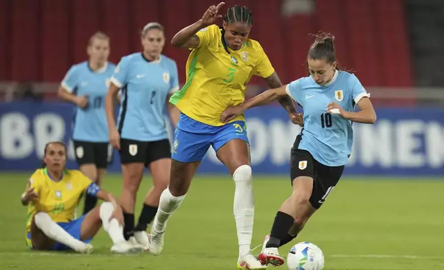 Uruguay's Belen Aquino, right, dribbles past Brazil's Tarciane during a Women's Copa America semifinal soccer match at Rodrigo Paz Delgado stadium in Quito, Ecuador, Tuesday, July 29, 2025. (AP Photo/Dolores Ochoa)