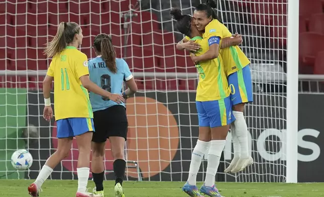 Brazil's Marta, right, celebrates with teammates after scoring her side's third goal against Uruguay, from the penalty spot, during a Women's Copa America soccer semifinal at Rodrigo Paz Delgado stadium in Quito, Ecuador, Tuesday, July 29, 2025. (AP Photo/Dolores Ochoa)