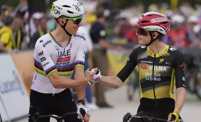 Slovenia's Tadej Pogacar, left, shakes hands with Denmark's Jonas Vingegaard at the start of the first stage of the Tour de France cycling race over 184.9 kilometers (114.9 miles) with start and finish in Lille, France, Saturday, July 5, 2025. (AP Photo/Mosa'ab Elshamy)