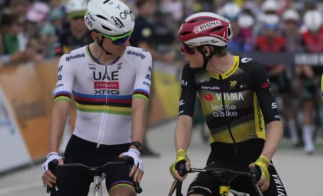 Slovenia's Tadej Pogacar, left, speaks with Denmark's Jonas Vingegaard at the start of the first stage of the Tour de France cycling race over 184.9 kilometers (114.9 miles) with start and finish in Lille, France, Saturday, July 5, 2025. (AP Photo/Mosa'ab Elshamy)