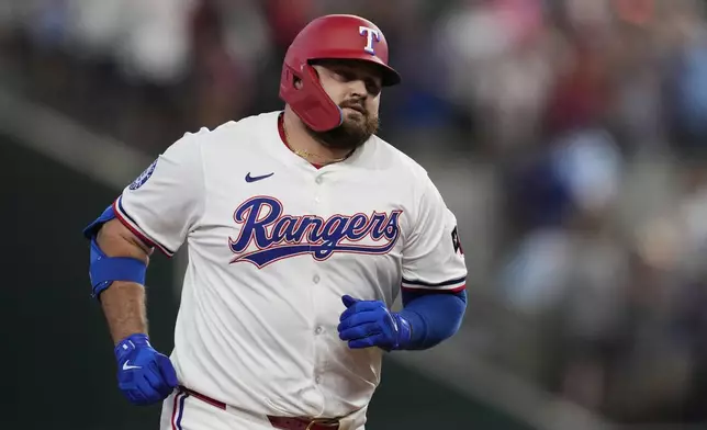 Texas Rangers' Rowdy Tellez rounds the bases after hitting a three-run home run that also scored Adolis Garcia and Wyatt Langford in the second inning of a baseball game against the Detroit Tigers, Saturday, July 19, 2025, in Arlington, Texas. (AP Photo/Tony Gutierrez)