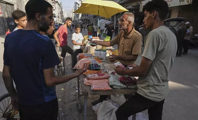 A Palestinian vendor displays goods for sale at a street market in Gaza City, Wednesday, July 23, 2025. (AP Photo/Jehad Alshrafi)