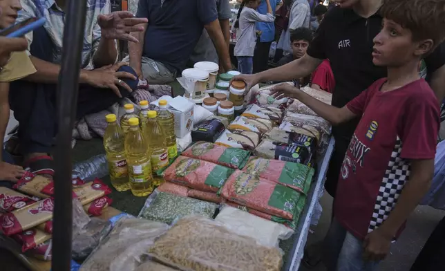 Palestinian vendors display goods for sale at a street market in Gaza City, Wednesday, July 23, 2025. (AP Photo/Jehad Alshrafi)