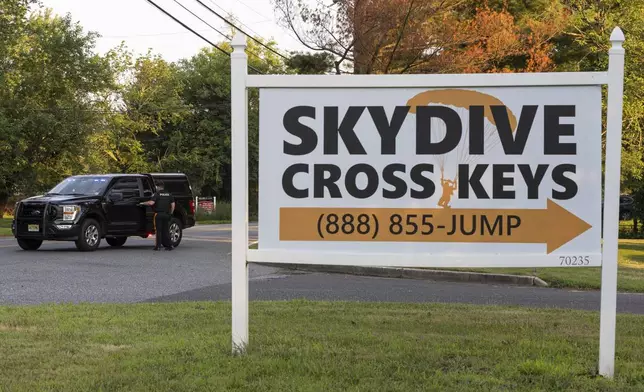 New Jersey State Police direct traffic near Cross Keys Airport in Gloucester County, N.J., after a skydiving aircraft went off the end of a runway and crashed into the woods Wednesday, July 2, 2025. (Kaiden J. Yu/The Philadelphia Inquirer via AP)