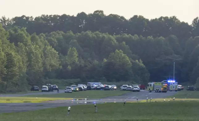 First responders work the scene at Cross Keys Airport in Gloucester County, N.J., after a skydiving aircraft went off the end of a runway and crashed into the woods Wednesday, July 2, 2025. (Kaiden J. Yu/The Philadelphia Inquirer via AP)