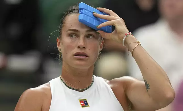 Aryna Sabalenka of Belarus uses an ice pack to keep cool during a change of ends break as she plays Belgium's Elise Mertens during a fourth round women's singles match at the Wimbledon Tennis Championships in London, Sunday, July 6, 2025. (AP Photo/Alastair Grant)