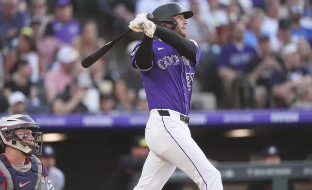 Colorado Rockies' Ryan McMahon follows the flight of his two-run home run off Minnesota Twins starting pitcher Zebby Matthews in the third inning of a baseball game Saturday, July 19, 2025, in Denver. (AP Photo/David Zalubowski)
