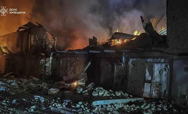 In this photo provided by the Ukrainian Emergency Service, first responders work to extinguish a fire following a Russian attack in Kyiv region, Ukraine, Friday, July 4, 2025. (Ukrainian Emergency Service via AP)