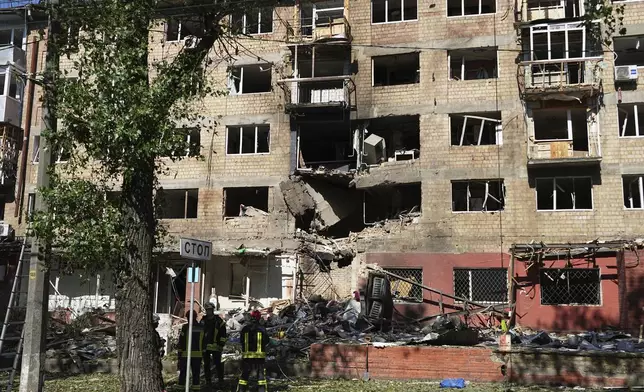 Firefighters work at a destroyed apartment building after a Russian drone and missile attacks in Kyiv, Ukraine, Friday, July 4, 2025. (AP Photo/Efrem Lukatsky)