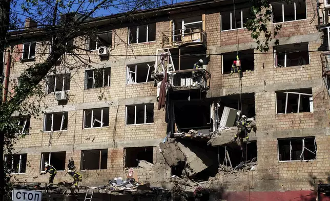 Rescue workers clear the rubble of a residential house damaged by a Russian strike in Kyiv, Ukraine, on Friday, July 4, 2025. (AP Photo/Evgeniy Maloletka)