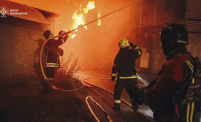 In this photo provided by the Ukrainian Emergency Service, first responders work to extinguish a fire following a Russian attack in Kyiv region, Ukraine, Friday, July 4, 2025. (Ukrainian Emergency Service via AP)