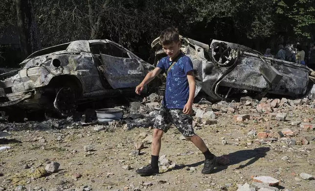 Damaged cars lie in a yard among other debris after a Russian drone and missile attacks in Kyiv, Ukraine, Friday, July 4, 2025. (AP Photo/Efrem Lukatsky)