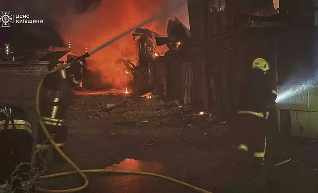 In this photo provided by the Ukrainian Emergency Service, first responders work to extinguish a fire following a Russian attack in Kyiv region, Ukraine, Friday, July 4, 2025. (Ukrainian Emergency Service via AP)