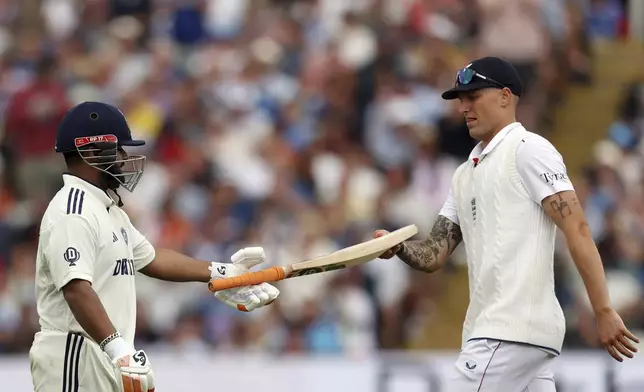 India's Rishabh Pant, left, is given his bat back by England's Brydon Carse during day four of the second cricket test match between England and India at Edgbaston in Birmingham, England, Saturday, July 5, 2025. (AP Photo/Scott Heppell)