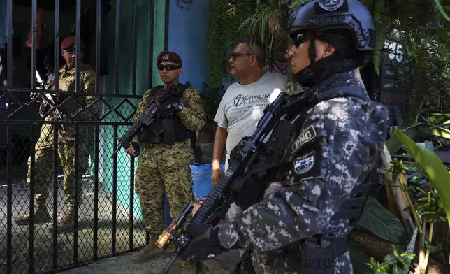 Police and soldiers stop to ask neighbors about an empty home as they patrol the San Bartolo neighborhood in El Salvador, Thursday, July 17, 2025. (AP Photo/Salvador Melendez)