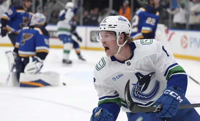 FILE - Vancouver Canucks' Brock Boeser, right, celebrates after scoring past St. Louis Blues goaltender Jordan Binnington, left, during the third period of an NHL hockey game, March 20, 2025, in St. Louis. (AP Photo/Jeff Roberson, file)