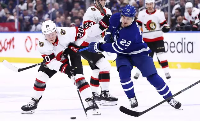 FILE - Ottawa Senators' Fabian Zetterlund (20) and Toronto Maple Leafs' Matthew Knies (23) battle for the puck during the first period of an NHL hockey playoff game in Toronto, on Tuesday, April 22, 2025. (Cole Burston/The Canadian Press via AP, File)