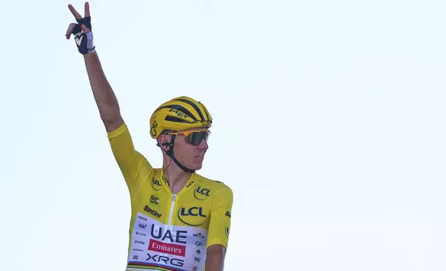 Slovenia's Tadej Pogacar, wearing the overall leader's yellow jersey, greets spectators prior to the start of the eighth stage of the Tour de France cycling race over 171.4 kilometers (106.5 miles) with start in Saint-Meen-le-Grand and finish in Laval Espace Mayenne, France, Saturday, July 12, 2025. (AP Photo/Thibault Camus)