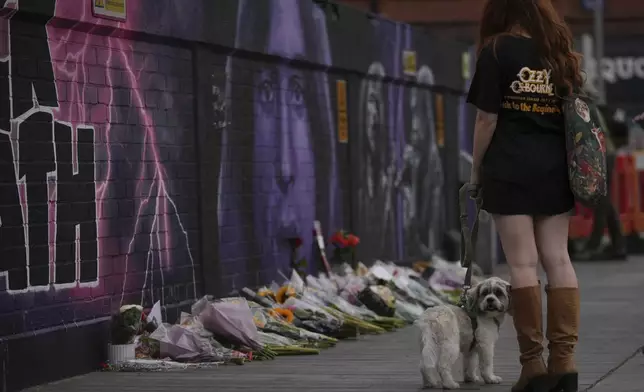 A music fan commemorates the death of Ozzy Osbourne in Birmingham, Wednesday, July 23, 2025. (AP Photo/Kin Cheung)