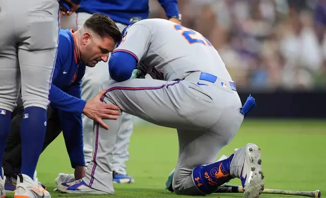 FILE - New York Mets' Juan Soto is checked by a trainer after fouling a ball off his left foot in the fourth inning of a baseball game against the San Diego Padres, Tuesday, July 29, 2025, in San Diego. (AP Photo/Gregory Bull, File)