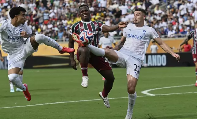 Fluminense's Jhon Arias, center, goes for the ball between Al Hilal's Kaio Cesar, left, and Sergej Milinkovic-Savic (22) during the Club World Cup quarterfinal soccer match between Fluminense and Al Hilal in Orlando, Fla., Friday, July 4, 2025. (AP Photo/Phelan M. Ebenhack)