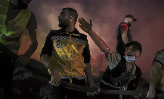 Syrian Civil Defense teams and volunteers battle wildfire flames for the tenth consecutive day near the town of Kasab, in Syria's Latakia countryside, early Saturday, July 12, 2025. (AP Photo/Ghaith Alsayed)