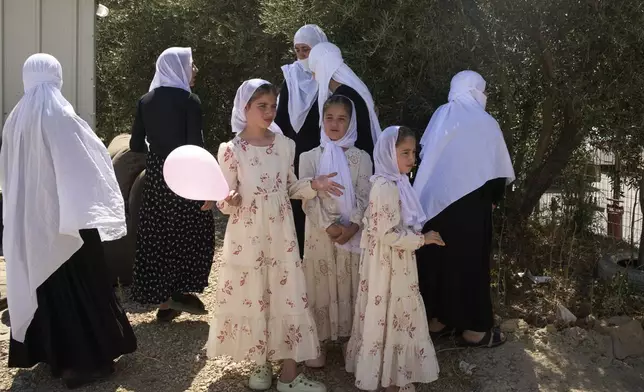 Druze women from Syria gather to cross back into Syria at the Israeli-Syrian border, from the Israeli-controlled Golan Heights town of Majdal Shams, Thursday, July 17, 2025. (AP Photo/Leo Correa)