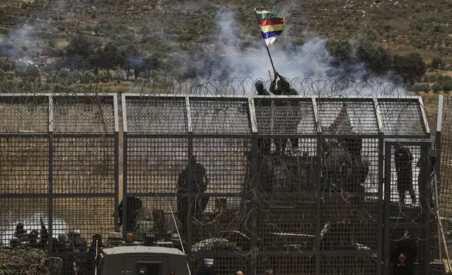 Syrian Druze protest near the Israeli-Syrian border, as seen from the town of Majdal Shams in the Israeli-controlled Golan Heights, Wednesday, July 16, 2025, amid the ongoing clashes between Syrian government forces and Druze armed groups in the southern Syrian city of Sweida. (AP Photo/Leo Correa)