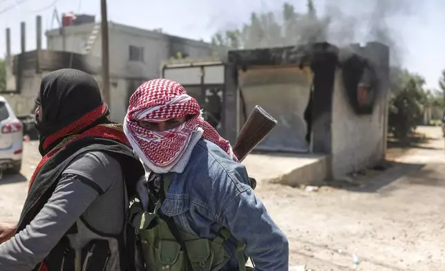 Bedouin fighters deploy at Mazraa village on the outskirts of Sweida city, during clashes between the Bedouin clans and Druze militias, southern Syria, Friday, July 18, 2025. (AP Photo/Ghaith Alsayed)