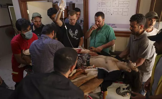 A Syrian government soldier who was injured in Sweida city during clashes between the Syrian government forces and Druze militias, receive treatments at a clinic in Busra al-Harir village, southern Syria, Tuesday, July 15, 2025. (AP Photo/Omar Albam)
