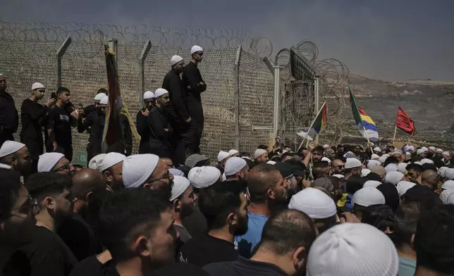Druze from Syria and Israel protest on the Israeli-Syrian border, in Majdal Shams in the Israeli-controlled Golan Heights, Wednesday, July 16, 2025, amid the ongoing clashes between Syrian government forces and Druze armed groups in the southern Syrian city of Sweida. (AP Photo/Leo Correa)