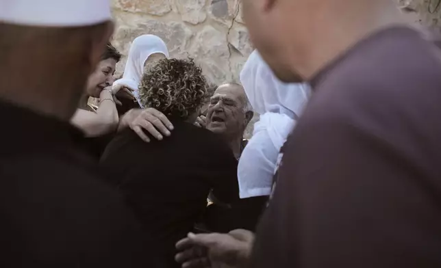 Salem Abu Jabel, center, a Syrian Druze, is greeted by relatives after crossing from Syria into Majdal Shams in the Israeli-controlled Golan Heights, Wednesday, July 16, 2025, amid the ongoing clashes between Syrian government forces and Druze armed groups in the southern Syrian city of Sweida. (AP Photo/Leo Correa)