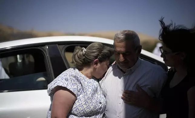 Syrian Druze, Fares Abu Zaid, 80, center, says goodbye to Druze relatives from Israel before crossing back into Syria at the Israeli-Syrian border, in the Israeli-controlled Golan Heights town of Majdal Shams, Thursday, July 17, 2025. (AP Photo/Leo Correa)