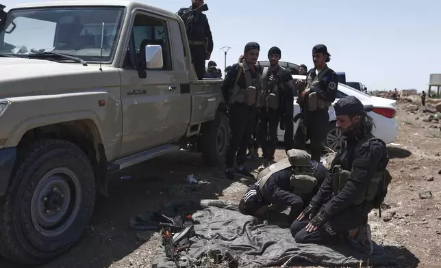 Syrian government security forces attend their noon prayer at Busra al-Harir village in Daraa, as they prepare to enter Sweida province where clashes erupted between Druze militias and Sunni Bedouin clans, southern Syria, Monday, July 14, 2025. (AP Photo/Omar Sanadiki)
