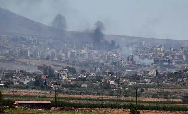 Smoke rise from clashes between Syrian government forces and Druze militias in Sweida city, southern Syria, Tuesday, July 15, 2025. (AP Photo/Omar Sanadiki)