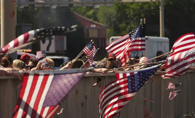 A crowd gathers on an overpass over I-90 to honor the firefighters who were killed Sunday, in Coeur d'Alene, Idaho, on Tuesday, July 1, 2025. (AP Photo/Lindsey Wasson)
