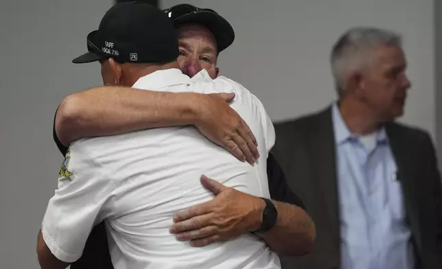 Kootenai County Fire &amp; Rescue commissioner Andy Boyle, facing, gets a hug following a press conference announcing the names of the firefighters killed and wounded the day before by a shooter while responding to a wildfire at Canfield Mountain, Monday, June 30, 2025, in Post Falls, Idaho. (AP Photo/Lindsey Wasson)