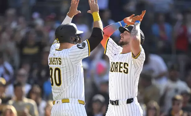 San Diego Padres' Jackson Merrill, right, celebrates with Gavin Sheets, left, after hitting a two-run home run during the second inning of a baseball game against the Philadelphia Phillies, Saturday, July 12, 2025, in San Diego. (AP Photo/Orlando Ramirez)