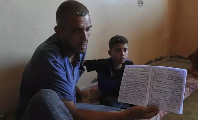 Nidal Al-Nouri shows a school notebook that belonged to his 13-year-old daughter Sama, who was killed in an Israeli strike while waiting to receive nutritional supplements at a medical clinic, during an interview at his family's home in Deir al-Balah, Gaza Strip, Friday, July 11, 2025. (AP Photo/Abdel Kareem Hana)