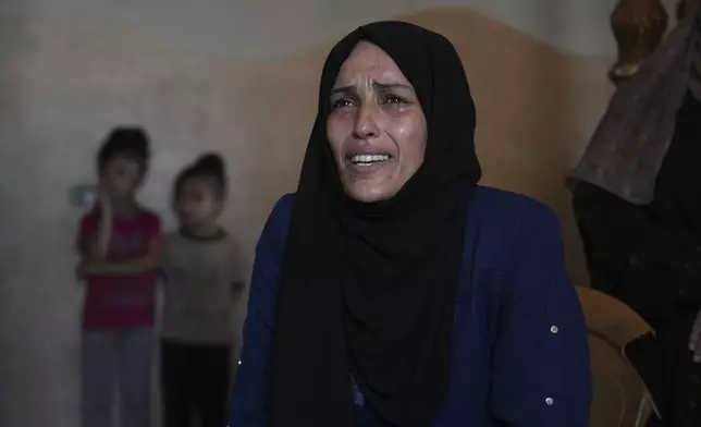 Iman Al-Nouri, the mother of two children who were killed, and one injured, in an Israeli strike while waiting to receive nutritional supplements at a medical clinic, reacts during an interview at her home in Deir al-Balah, Gaza Strip, Friday, July 11, 2025. (AP Photo/Abdel Kareem Hana)
