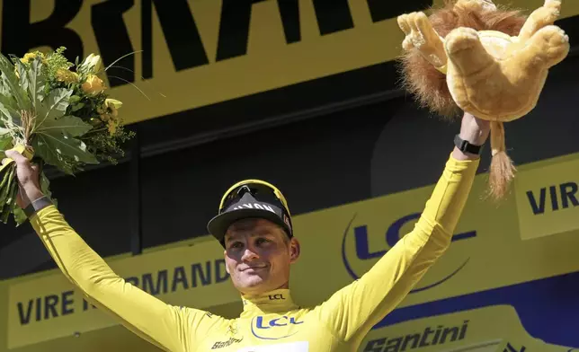 Netherlands' Mathieu van der Poel wearing the overall leader's yellow jersey celebrates on the podium after the sixth stage of the Tour de France cycling race over 201.5 kilometers (125.2 miles) with start in Bayeux and finish in Vire Normandy, France, Thursday, July 10, 2025. (AP Photo/Mosa'ab Elshamy)