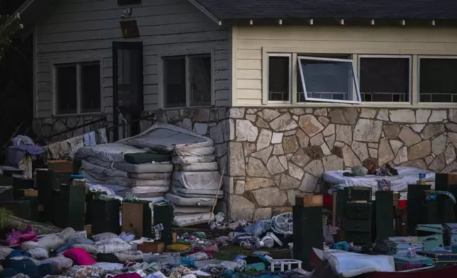 Camper's belongings sit outside one of Camp Mystic's cabins near the Guadalupe River, Monday, July 7, 2025, in Hunt, Texas, after a flash flood swept through the area. (AP Photo/Eli Hartman)