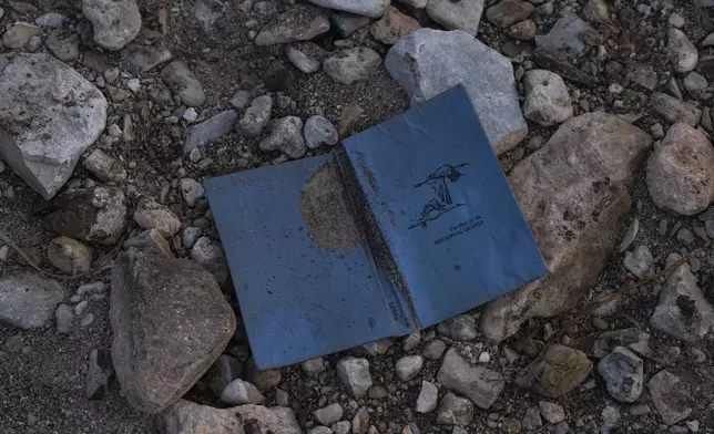 A copy of "The Hunt for the Whooping Cranes" sits on the bank of the Guadalupe River across from Camp Mystic, Monday, July 7, 2025, in Hunt, Texas, after a flash flood swept through the area. (AP Photo/Eli Hartman)