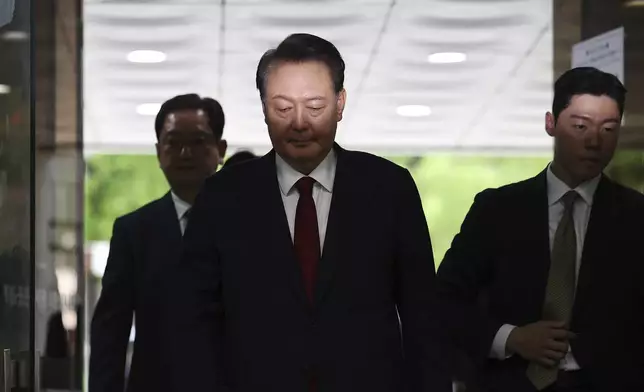 Former South Korean President Yoon Suk Yeol, centerm arrives at a court to attend a hearing to review his arrest warrant requested by special prosecutors in Seoul, South Korea Wednesday, July 9, 2025. (Kim Hong-Ji/Pool Photo via AP)