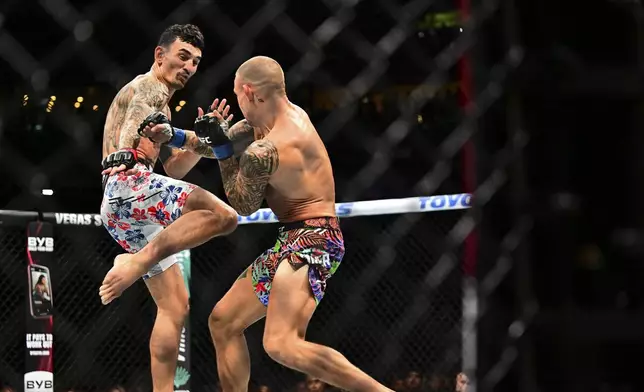 Dustin Poirier, right, fights against Max Holloway in a lightweight title fight at UFC 318 in New Orleans, La., Saturday, July 19, 2025. (AP Photo/Ella Hall)