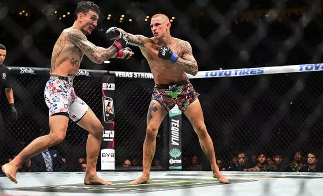 Dustin Poirier, right, hits Max Holloway in a lightweight title fight at UFC 318 in New Orleans, La., Saturday, July 19, 2025. (AP Photo/Ella Hall)