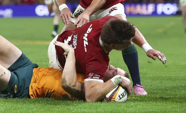 Huw Jones of the British &amp; Irish Lions, top, is tackled by Australia's Max Jorgensen and has his try disallowed for not releasing the ball during their first rugby union test in Brisbane, Australia, Saturday, July 19, 2025. (AP Photo/Pat Hoelscher)
