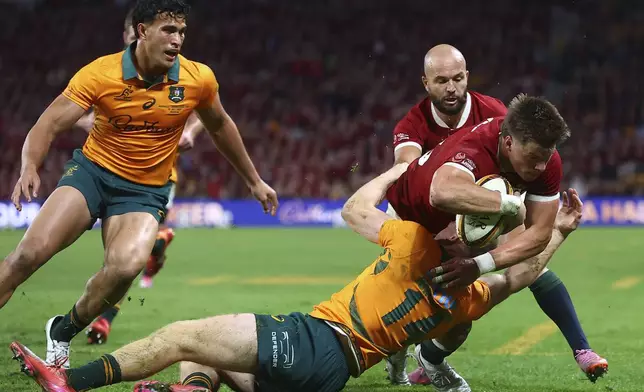Huw Jones of the British &amp; Irish Lions, right, is tackled by Australia's Max Jorgensen and has his try disallowed for not releasing the ball during their first rugby union test in Brisbane, Australia, Saturday, July 19, 2025. (AP Photo/Pat Hoelscher)