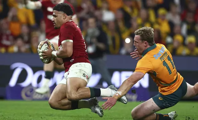 Sione Tuipulotu of the British &amp; Irish Lions, left, gets past Australia's Harry Potter to score a try during their first rugby union test in Brisbane, Australia, Saturday, July 19, 2025. (AP Photo/Pat Hoelscher)